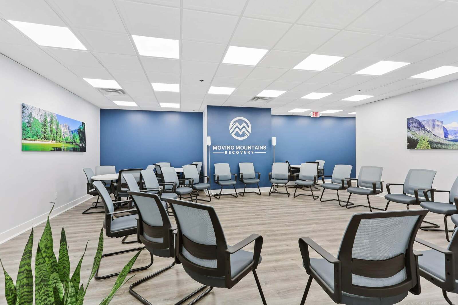 Clinical outpatient group therapy room with Moving Mountains logo wall